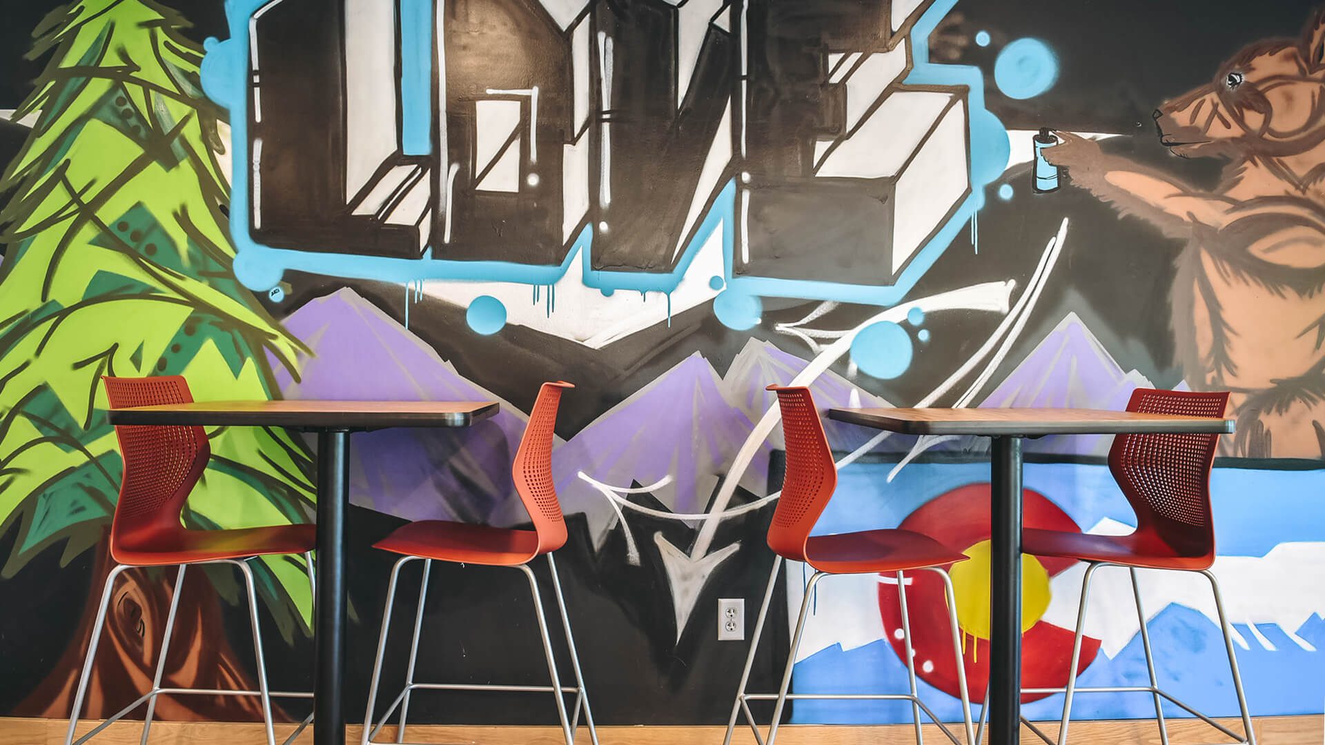 Table and chairs in front of graffiti artwork mural